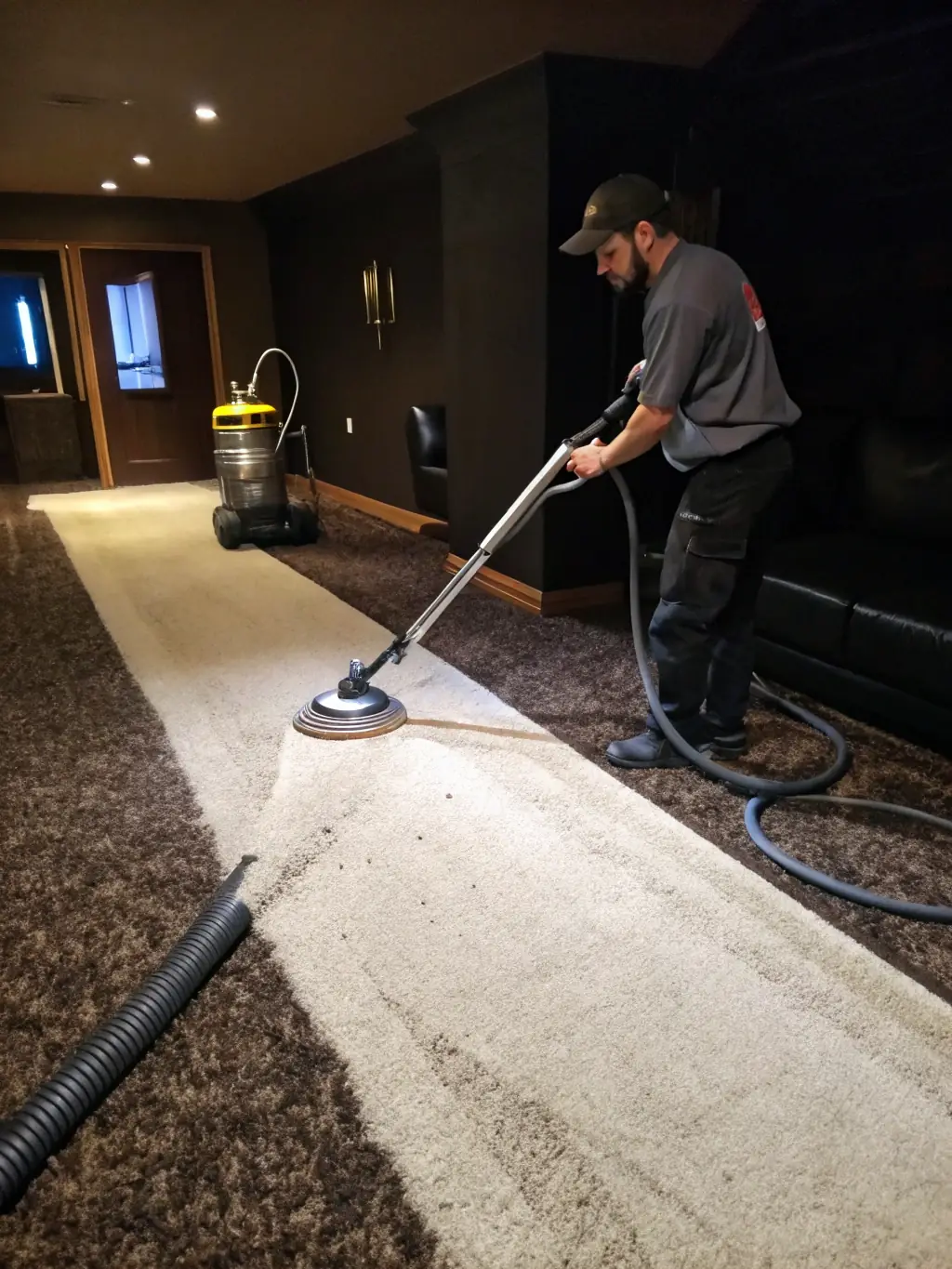 A close-up shot of a plush carpet being steam cleaned, with visible dirt and grime being extracted, showcasing the thorough cleaning process.